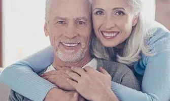 A couple smiling after full mouth rehabilitation.