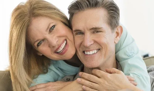 A couple smiling, from the practice's own restorative dentistry page.